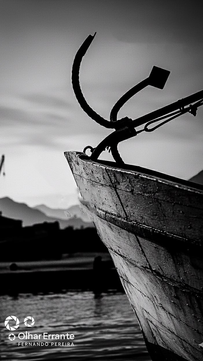 Proa de embarcação em primeiro plano, madeira e ferragens